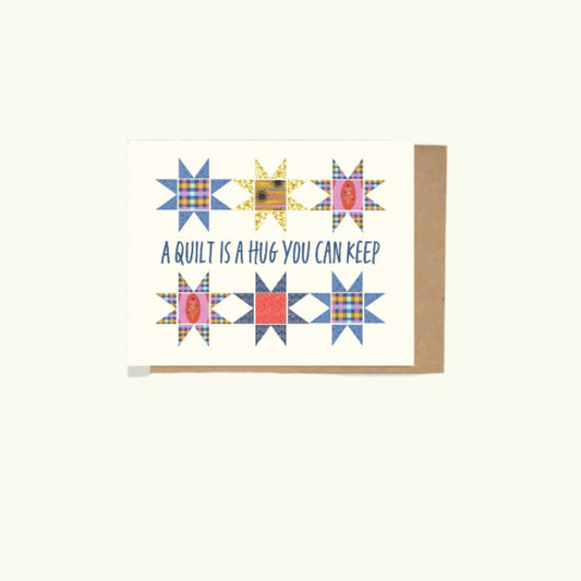 A greeting card with 6 quilt blocks on the front and also stating 'A Quilt is A Hug You Can Keep' 