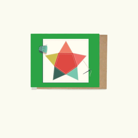 A greeting card with a hand-quilted star design, needle, and thimble, presented on a beige background with a green border.

