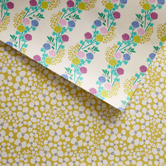Double-sided gift wrap paper with a floral design on one side and a striped pattern with rose vines on the other, both sides visible.

