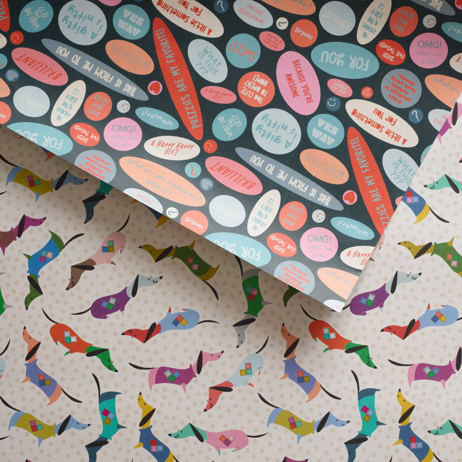 Double-sided wrapping paper with a pattern of colorful dachshunds wearing sweaters on one side and various gift-giving phrases on the reverse.

